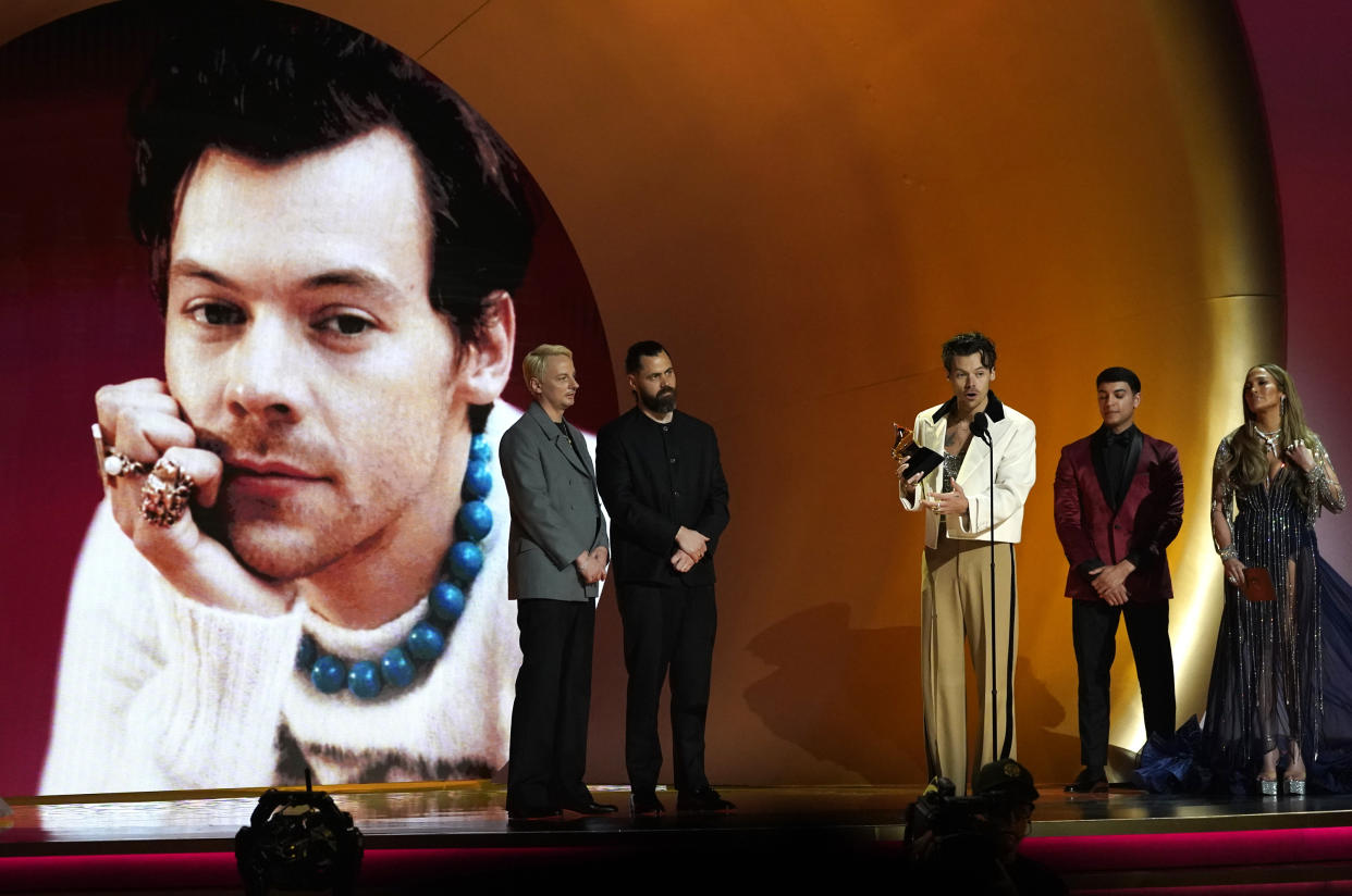 Harry Styles accepts the award for best pop vocal album for "Harry's House" at the 65th annual Grammy Awards on Sunday, Feb. 5, 2023, in Los Angeles. Jennifer Lopez looks on from far right. (AP Photo/Chris Pizzello)