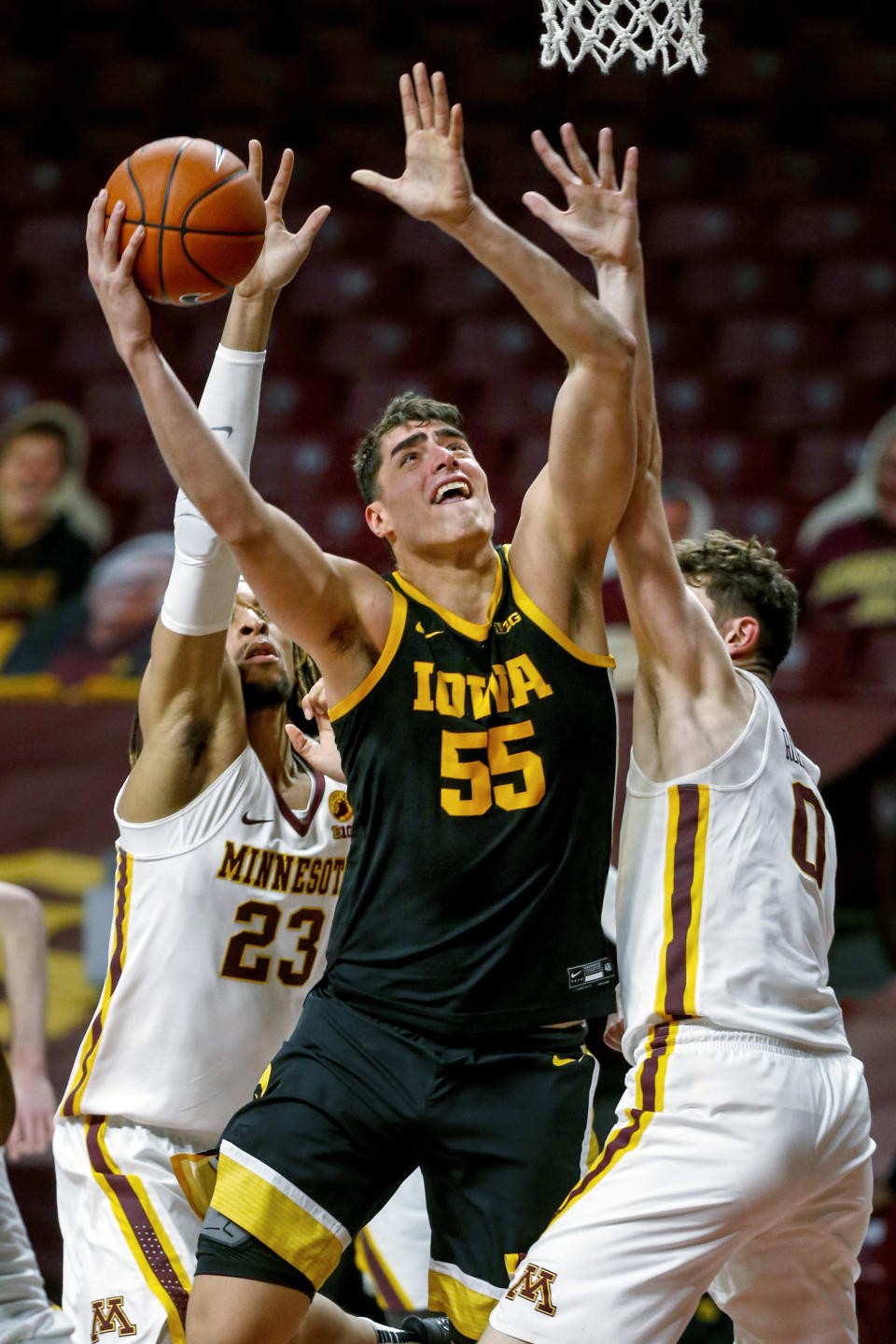 FILE - Iowa center Luka Garza (55) shoots between Minnesota forward Brandon Johnson (23) and center Liam Robbins (0) during the second half of an NCAA college basketball game in Minneapolis, in this Friday, Dec. 25, 2020, file photo. Garza was named The Associated Press men's basketball player of the year on Thursday, April 1, 2021. (AP Photo/Bruce Kluckhohn, File)