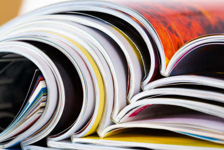 Closeup background of a pile of old magazines with bending pages