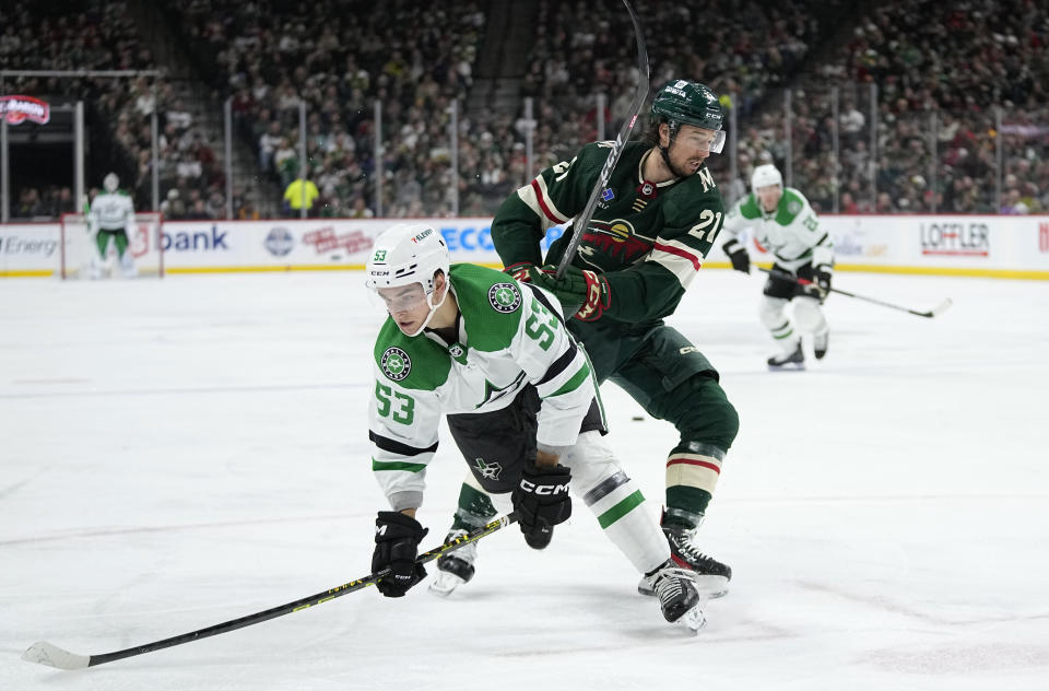 Dallas Stars center Wyatt Johnston (53) is pushed by Minnesota Wild right wing Brandon Duhaime (21) during the second period of an NHL hockey game Friday, Feb. 17, 2023, in St. Paul, Minn. (AP Photo/Abbie Parr)