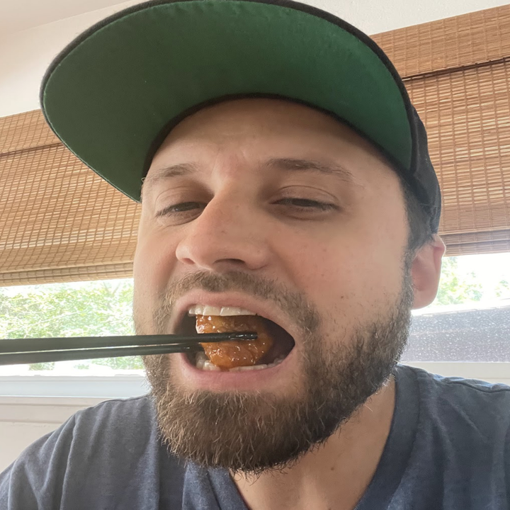 Andy Golder eating a piece of orange chicken