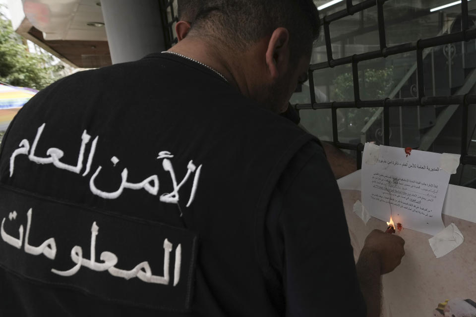 A Lebanese General Security officer seals a shop employing Syrian workers, as part of a crackdown on businesses employing unregistered Syrian workers, in Beirut, Lebanon, Saturday, May 11, 2024. Hundreds of Syrians refugees left a remote northeastern Lebanese town back to Syria in a convoy Tuesday, amid a surge in anti-refugee sentiment in the small, crisis-hit country. The new push for repatriation comes as Lebanon's quarrelling ruling political parties have reached a rare consensus in recent years, all agreeing that Syrian refugees should be returned. (AP Photo/Hassan Ammar)