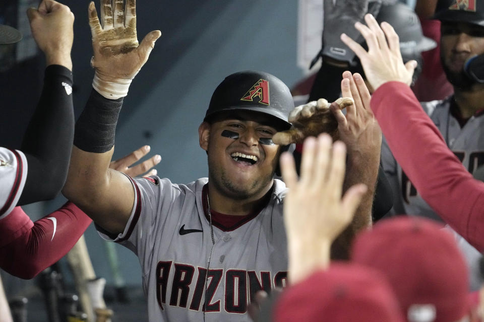 Arizona Diamondbacks' Gabriel Moreno, right, is congratulated by teammates in the dugout after hitting a two-run home run during the fourth inning of a baseball game against the Los Angeles Dodgers Monday, Aug. 28, 2023, in Los Angeles. (AP Photo/Mark J. Terrill)