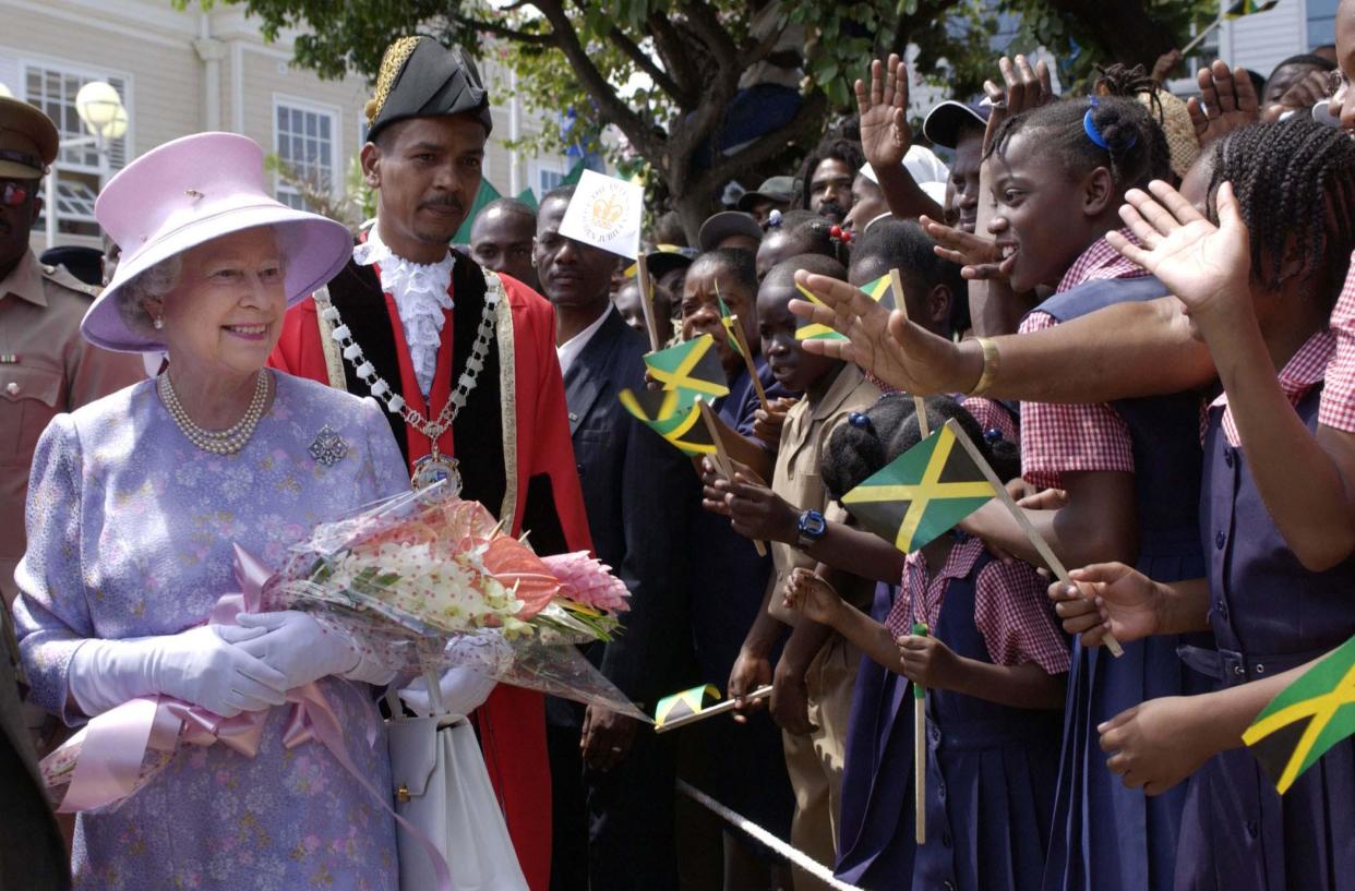 Queen Elizabeth II, accompanied by the Mayor of Montego Bay, Hugh Solomon, meets locals at Sam Sharpe Square, Montego Bay Jamaica, during her Jubilee overseas tour.   (Photo by Fiona Hanson - PA Images/PA Images via Getty Images)