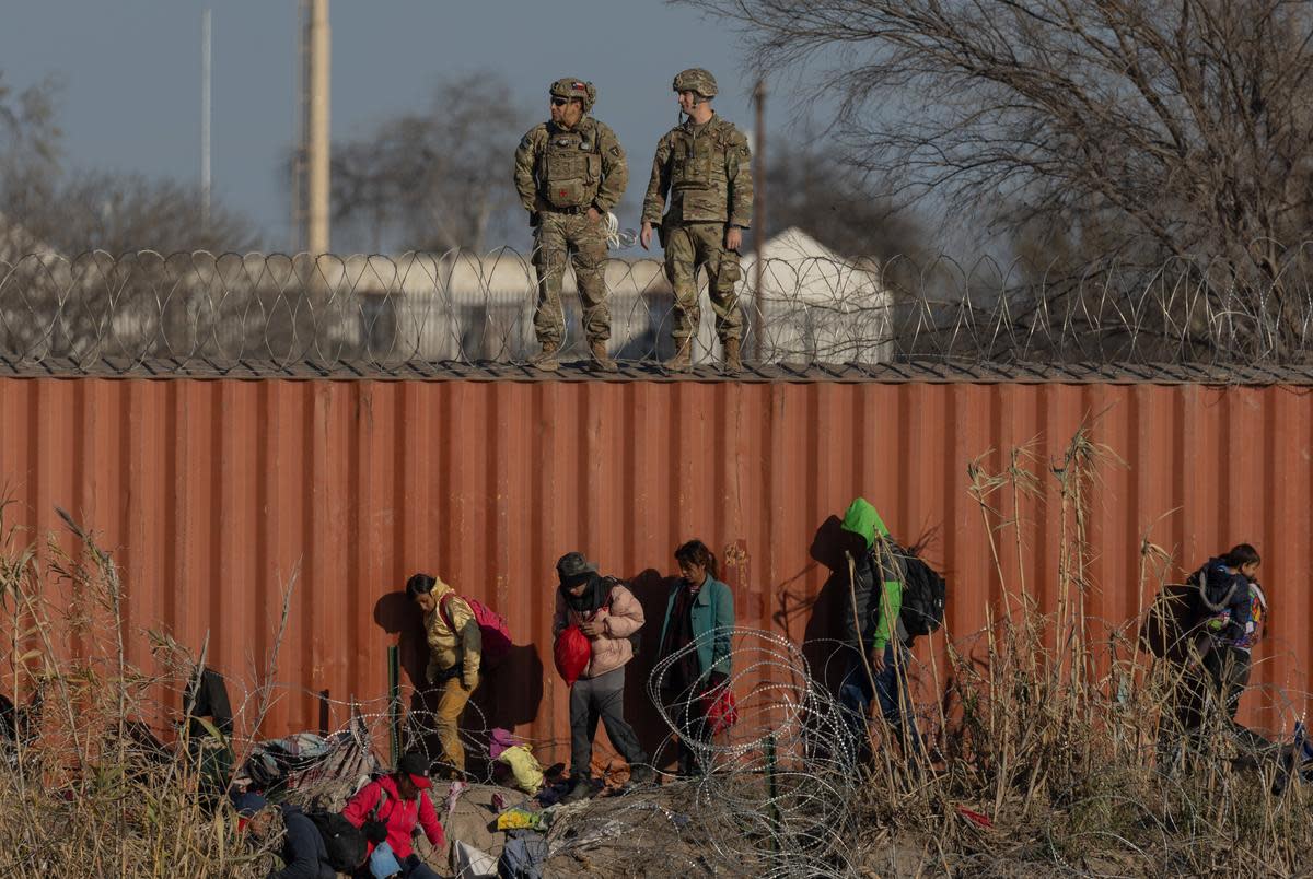 Migrants traverse the bank of the Rio Grande at Shelby Park in Eagle Pass, on Jan. 19, 2024.