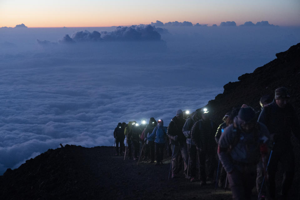 Un grupo de excursionistas sube a la cima del Monte Fuji, en Japón, justo antes del amanecer, mientras las nubes están por debajo de la cumbre.<br><br>Foto: AP Photo/Jae C. Hong