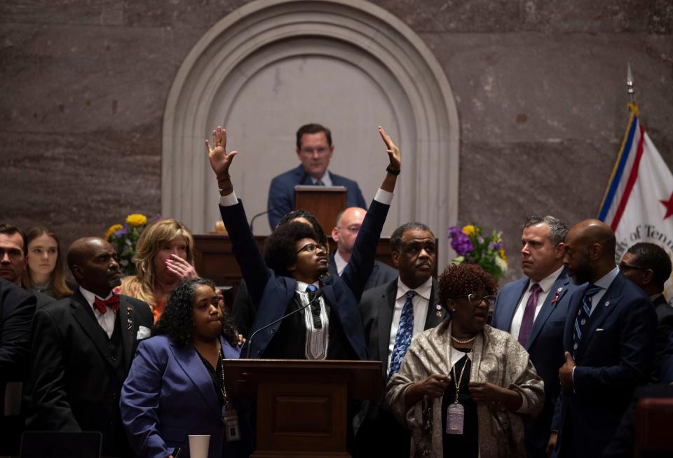 Justin Pearson, D-Memphis, is surrounded by supporters and lifts his hands to supporters in the gallery as he speaks before a vote to expel him form the House of Representatives at the Tennessee State Capitol in Nashville, Tenn., on Thursday, April 6, 2023.