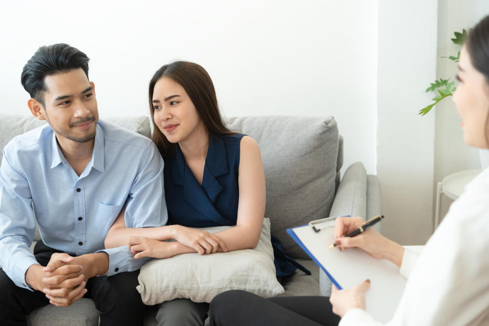 A couple sitting on the couch in the room to consult with a relationship counsellor.