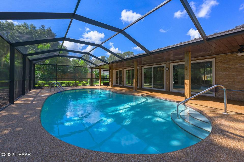 New sliders open to the spacious pool area with a covered porch, a resurfaced pool deck and a pool enclosure that was replaced in 2018.