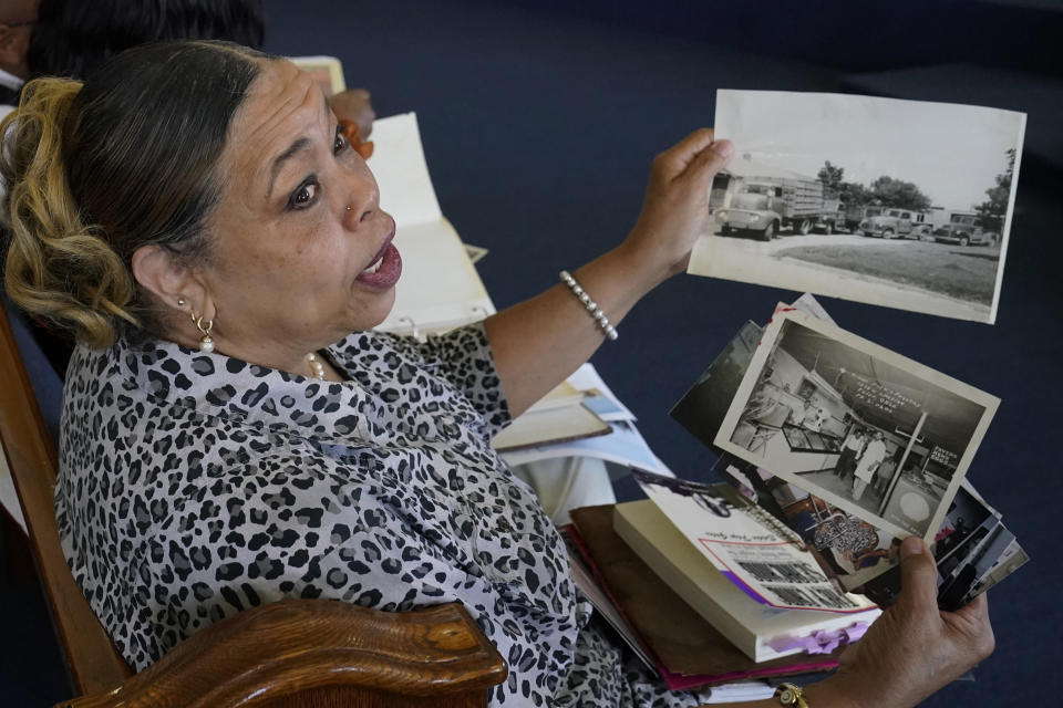 Carolyn Roberts, daughter of Tulsa Race Massacre survivor Ernestine Alpha Gibbs, holds family photos of the Gibbs family business during an interview in Tulsa, Okla., on Sunday, April 11, 2021. Roberts said although her parents lived with the trauma of the massacre, it never hindered their work ethic: “They survived the whole thing and bounced back.” (AP Photo/Sue Ogrocki)