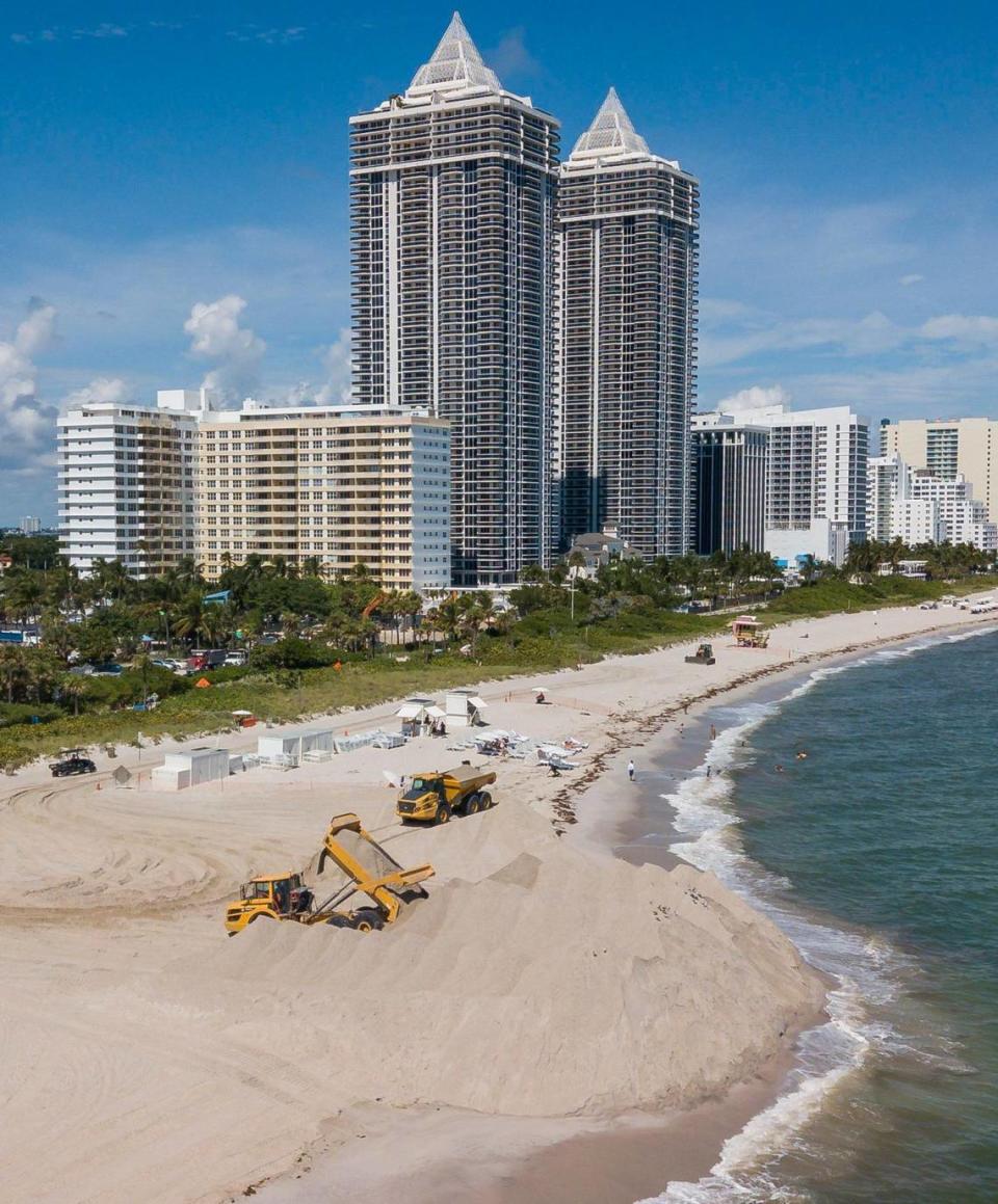 Trucks offload sand near an eroded stretch of shoreline near Indian Beach Park on Wednesday, Oct. 12, 2022, in Miami Beach, Fla.