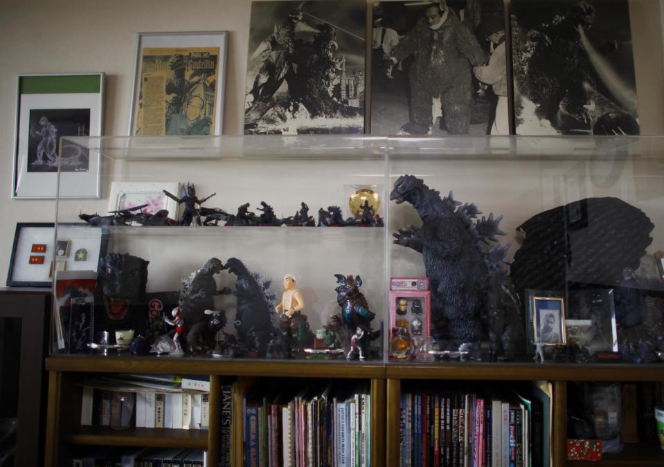 In this Monday, April 28, 2014 photo, collection of mementos about Godzilla are displayed in a showcase as original suit actor Haruo Nakajima, who has played his role as the monster, at his home in Sagamihara, near Tokyo. “It’s not some cowboy movie,” Nakajima, 85, said proudly, sitting among sepia-toned photos of him as a young man and Godzilla figures in his apartment. “Everyone asks me to play Godzilla again,” he said. “My Godzilla was the best.” (AP Photo/Junji Kurokawa)