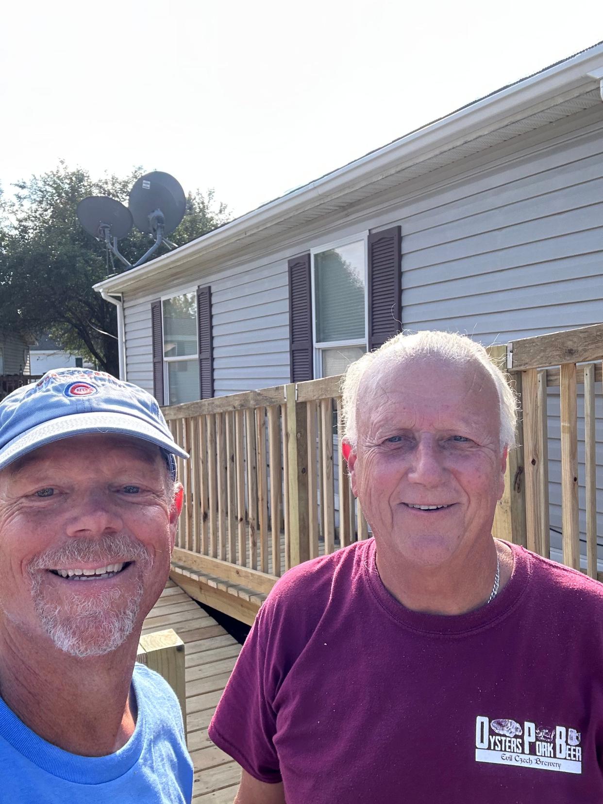 Doug Fecher and Kenn Andrews pose during construction of a ramp for a Clay United Methodist Church member. They are members of Helping Hands.