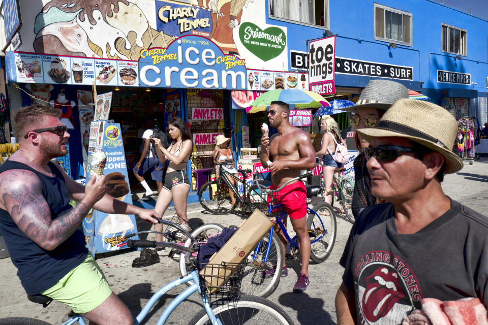 Tourists eat ice cream to cool off along the Venice Beach strand in Los Angeles, Tuesday, July 24, 2108. Scorching heat radiated across the U.S. Southwest on Tuesday, with the highest temperatures expected in California's Death Valley during a week that forecasters say could prove to be the region's hottest this year. (AP Photo/Richard Vogel)