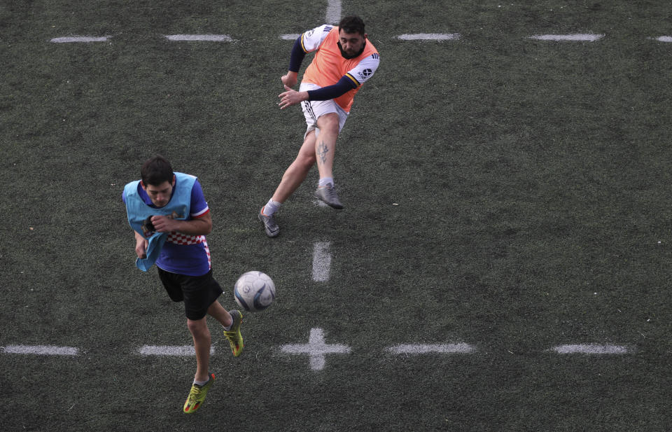 A man connects a shot during an amateur soccer match at a local club, Play Futbol 5, in Pergamino, Argentina, Wednesday, July 1, 2020. The club divided a soccer field into 12 rectangles to mark limited areas for each player, keeping them from making physical contact, an adaptation to continue playing amid government restrictions to curb the spread of the new coronavirus. (AP Photo/Natacha Pisarenko)