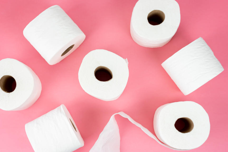 Top view of rolls of toilet tissue on pink background