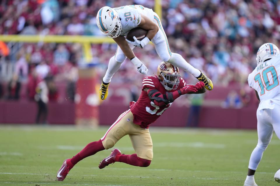 Miami Dolphins fullback Alec Ingold (30) hurdles against San Francisco 49ers linebacker Dre Greenlaw during the first half of an NFL football game in Santa Clara, Calif., Sunday, Dec. 4, 2022