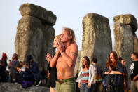 <p>People watch the sun rise on the Stonehenge monument on the summer solstice near Amesbury, Britain, June 21, 2017. (Photo: Neil Hall/Reuters) </p>