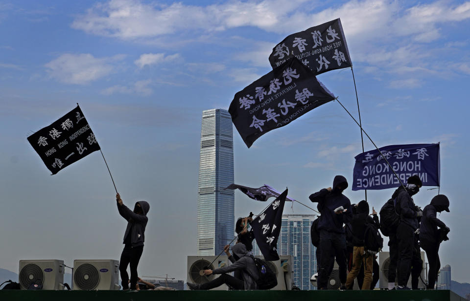 Manifestantes ondean banderas que dicen "Independencia de Hong Kong" durante una marcha en Hong Kong, el domingo 12 de enero de 2020. (AP Foto/Vincent Yu)