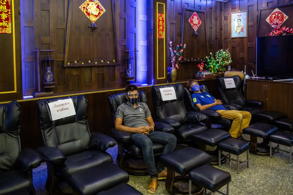 Massage parlor staff sit in socially distanced chairs on their first day of reopening after the COVID-19 pandemic restrictions were lifted on June 1, 2020 in Bangkok, Thailand. (Photo by Lauren DeCicca/Getty Images)