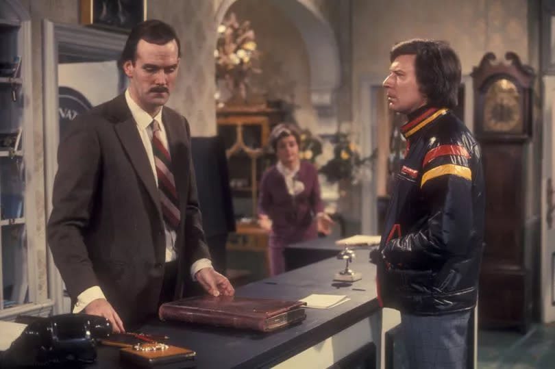 John Cleese, left, as hapless hotelier Basil Fawlty in the BBC sitcom Fawlty Towers -Credit:BBC