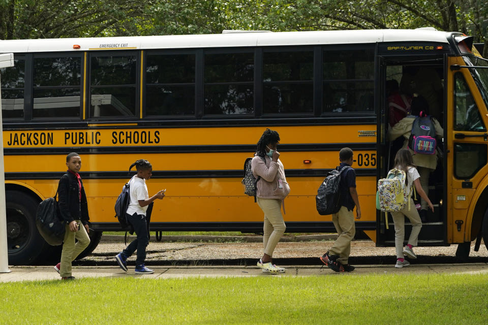 Spann Elementary School students board a school bus following a full day of in-school learning after having to again undertake virtual learning classes due to the city's water issues that forced Jackson Public Schools to close for several days, Tuesday, Sept. 6, 2022, in Jackson, Miss. (AP Photo/Rogelio V. Solis)