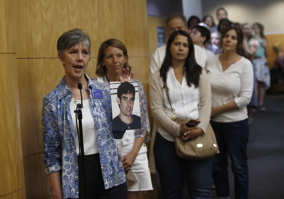 Terry Roark displays a photo of her son, Thomas, who she said was harmed by vaccines given to him when he was an infant in the early 1970's, as she and others express their opposition to a proposal to give state public health officials instead of local doctors the power to decide which children can skip their shots before attending school, at the Capitol Wednesday, April 24, 2019, in Sacramento, Calif. The bill, by state Sen. Richard Pan, D-Sacramento, a pediatrician, said his legislation would give state health officials the tools they need to prevent outbreaks of vaccine-preventable diseases like measles. (AP Photo/Rich Pedroncelli)