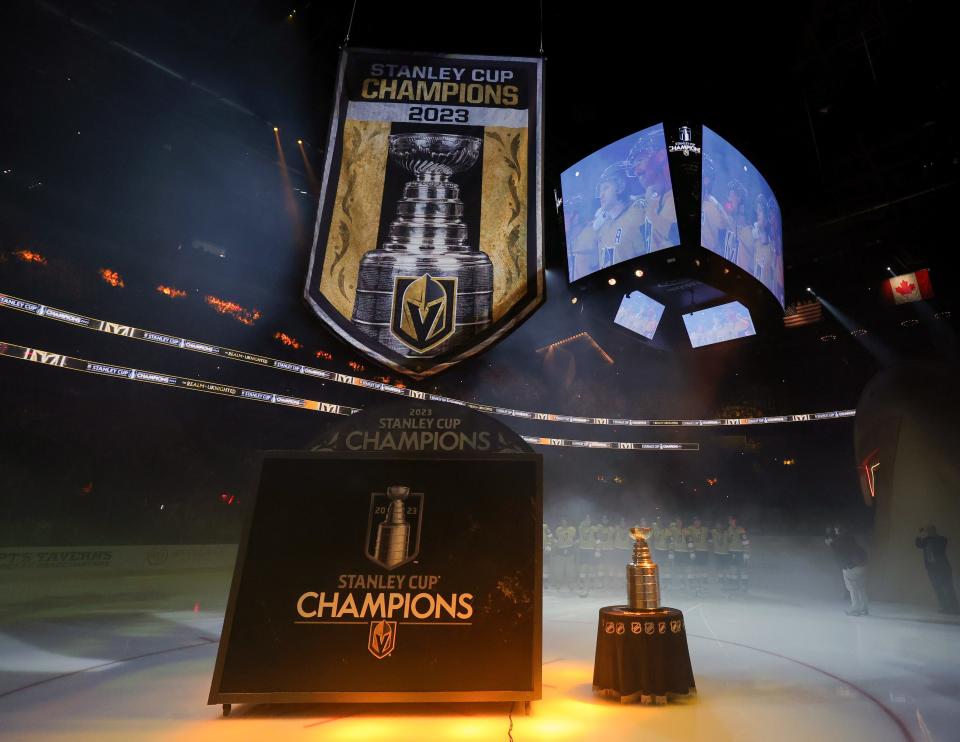 The Stanley Cup is displayed as Vegas Golden Knights players watch their championship banner being raised during a ceremony before the team's home opener against the Seattle Kraken.