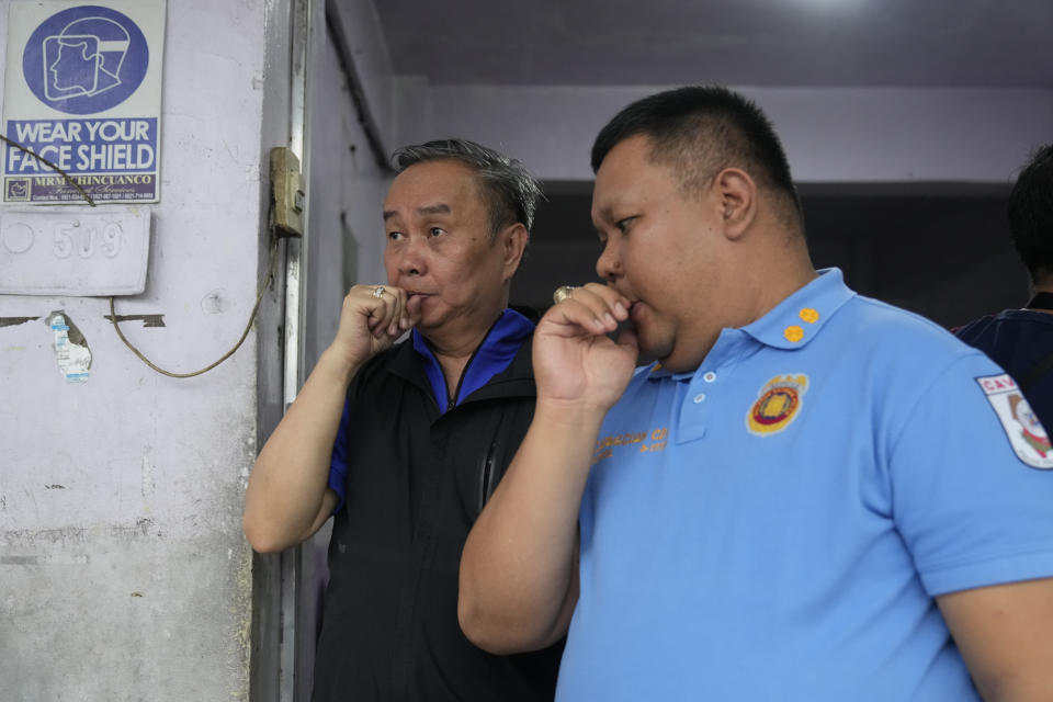 Tagaytay Mayor Abraham N. Tolentino, left, talks with Tagaytay Chief of Police, Police Lt. Col. Charles Daven Capagcuan at a mortuary in Silang, Cavite province, south of Manila, Philippines on Thursday, July 11, 2024. Two Australian nationals and their Filipina companion were killed at the Lake Hotel and police efforts were underway to identify and track down suspects, officials said. (AP Photo/Aaron Favila)