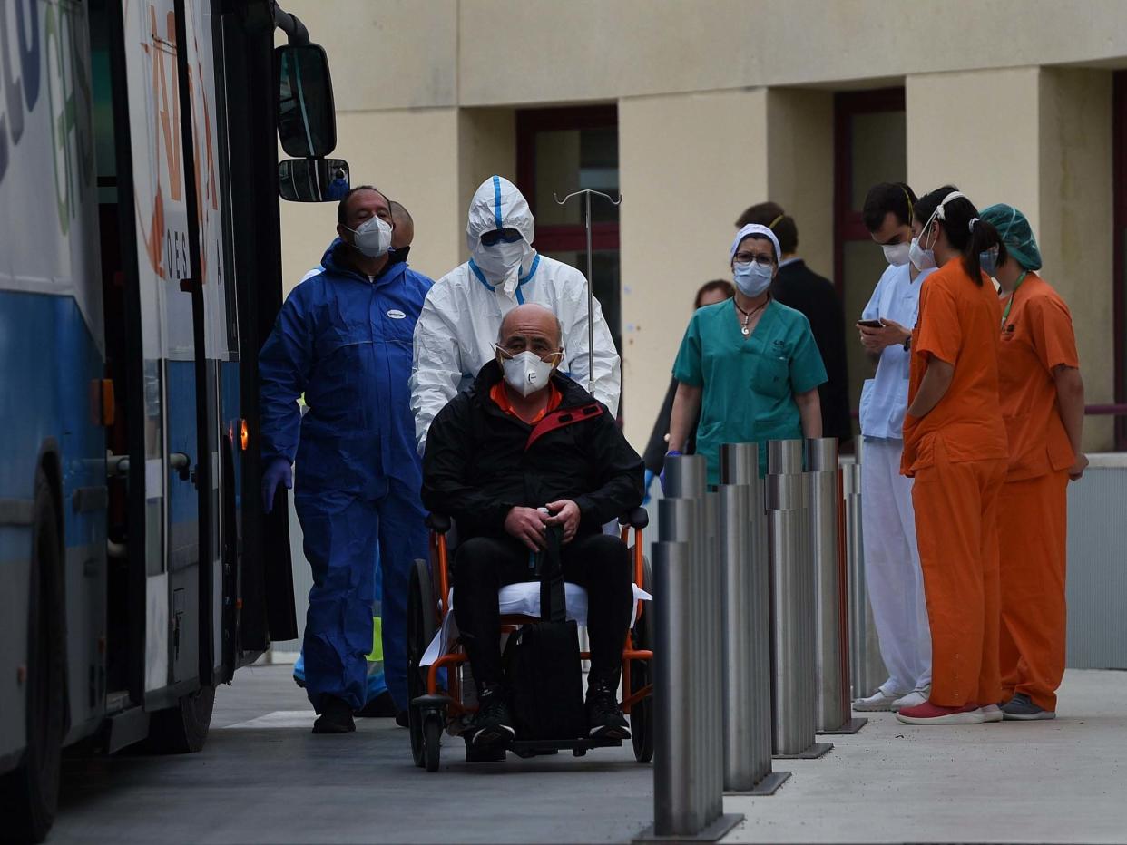 A patient is taken from Gregorio Marinon hospital onto a waiting bus to go to the IFEMA field hospital: Getty Images