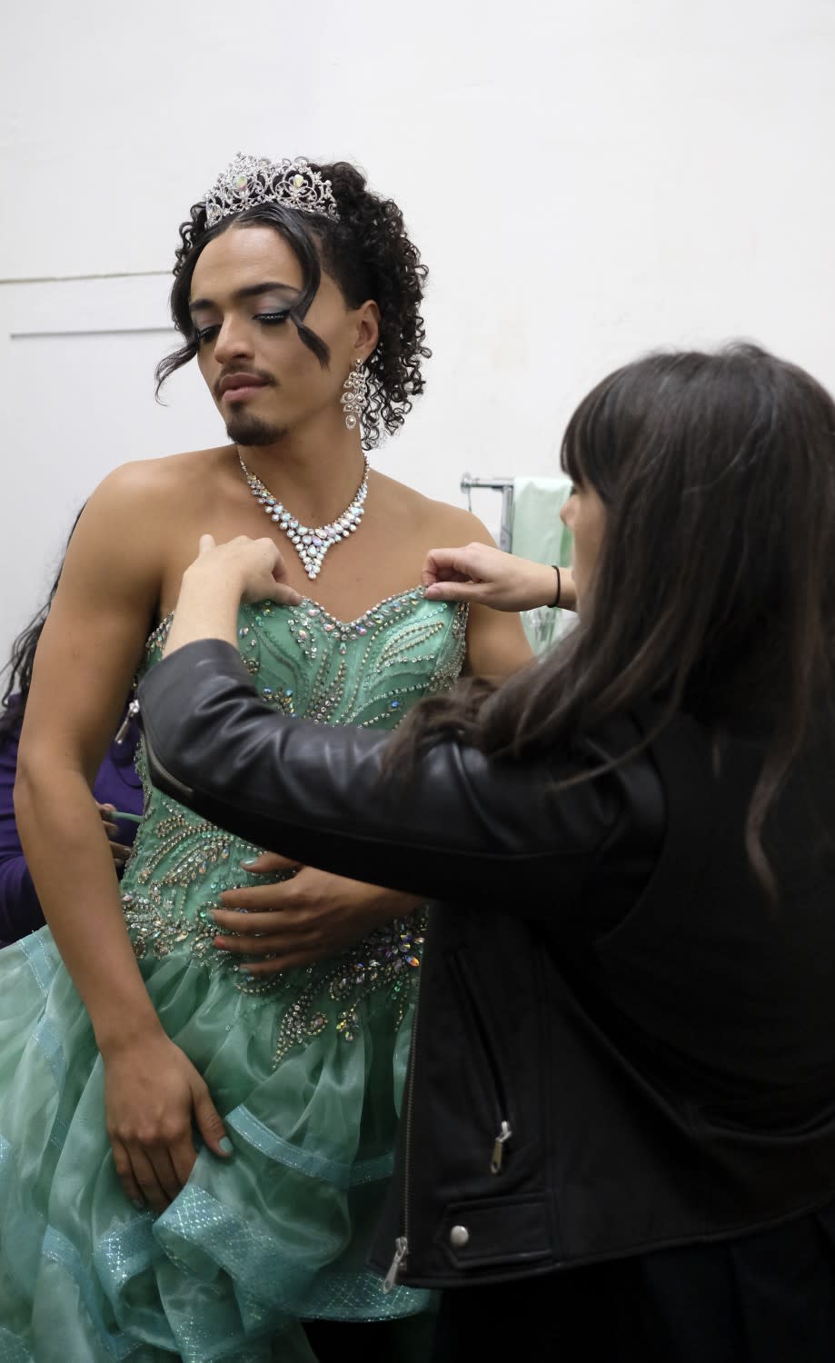 Costumer designer Hannah Jacobs, right, helps Tonatiuh, center, get dressed before walking on set.