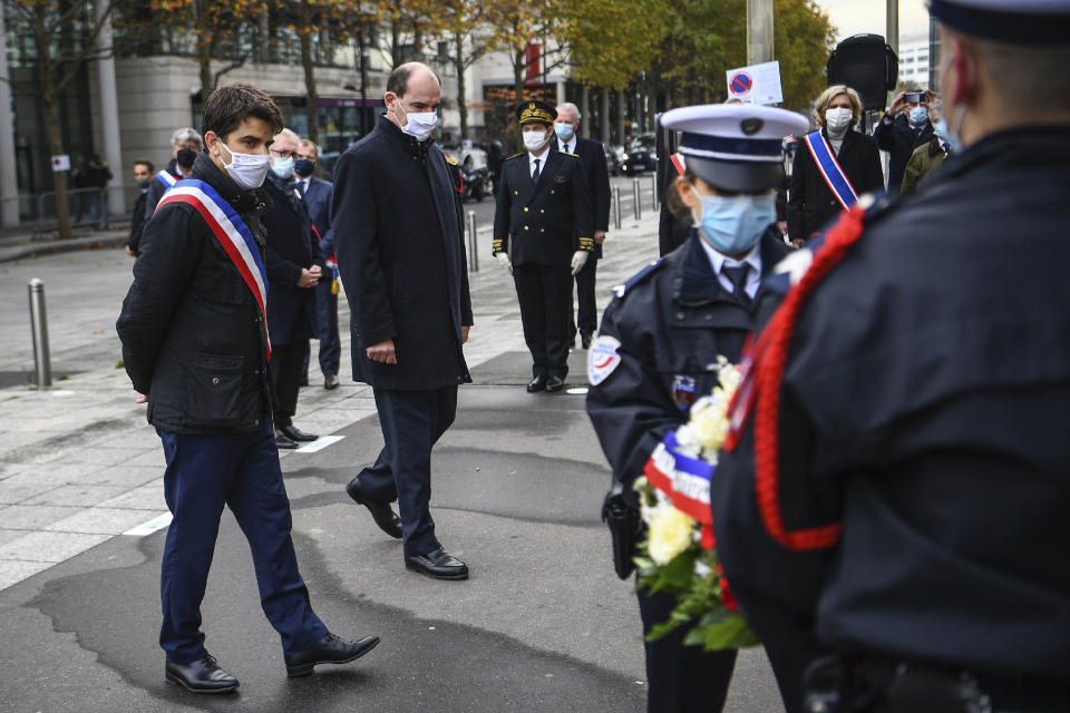 Saint-Denis Mayor Mathieu Hanotin, left, and French Prime Minister Jean Castex participate in a wreath laying ceremony, marking the 5th anniversary of the Nov. 13, 2015 attacks outside the stadium Stade de France in Saint Denis, near Paris, Friday, Nov. 13, 2020. In silence and mourning, France is marking five years since 130 people were killed by Islamic State extremists who targeted the Bataclan concert hall, Paris cafes and the national stadium. (Christophe Archambault/Pool Photo via AP)