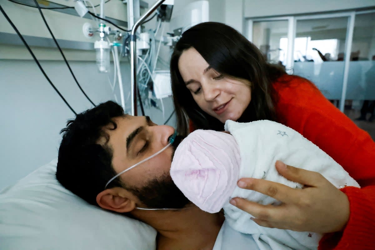 Mustafa Avci, 33, who was stuck under rubble for 261 hours, meets his daughter Almile for the first time and reunites with his wife Bilge, following the deadly earthquake, at a hospital in Mersin, Turkey (Reuters)