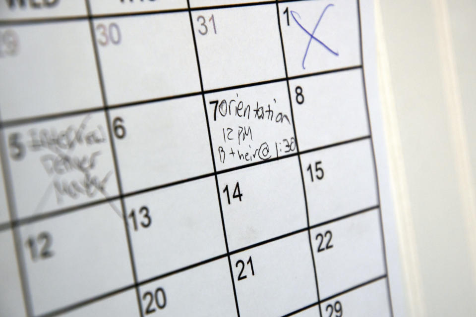 A calendar marking an orientation date hangs on the wall of Eric Martinez's room at a micro community in Denver on Wednesday, June 5, 2024. Martinez along with the others were directed into the micro communities of small cabin-like structures with a twin bed, desk and closet, after his Denver tent encampment was swept. The city built three such communities with nearly 160 units total in about six months, at roughly $25,000 per unit. (AP Photo/Thomas Peipert)