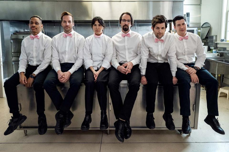 party down season 3 cast in white button ups, pink bows, black pants hanging out in catering kitchen and looking dejected