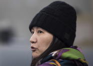 Huawei chief financial officer Meng Wanzhou talks with a member of her private security detail after they went into a wrong building while arriving at a parole office in Vancouver, British Columbia, Wednesday, Dec. 12, 2018. (Darryl Dyck/The Canadian Press via AP)