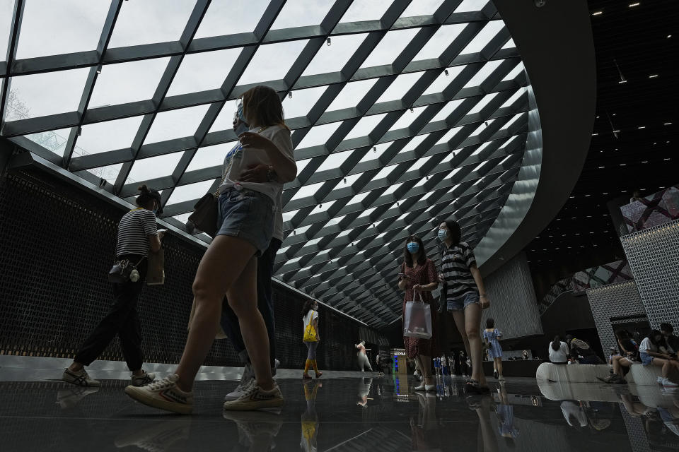 People wearing face masks to help curb the spread of the coronavirus visit a shopping mall in Beijing, Sunday, June 6, 2021. (AP Photo/Andy Wong)