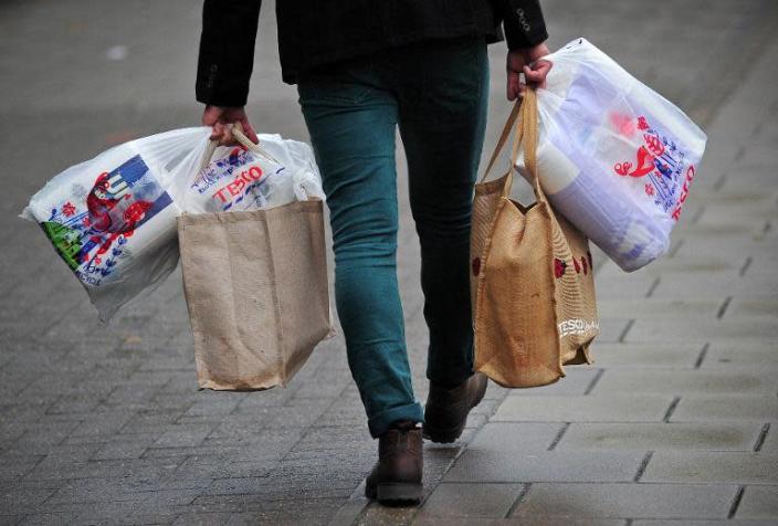 A man carries his shopping after visiting a Tesco store in south London, on October 2, 2013 (AFP Photo/Carl Court)