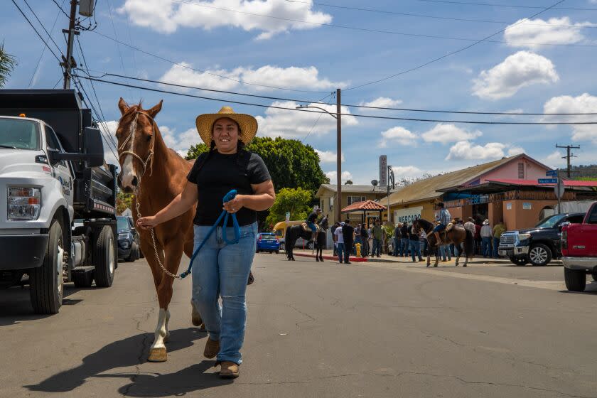 WHITTIER, CA - MAY 06: Jazmin Angel,32, takes her horse Boots for a walk to nearby San Gabriel River eastern banks trail. Behind residents from equestrian communities across Southern California gathered at town square in the unincorporated community of Pellissier Village near Whittier to discuss how to fight back against what they say is unfair code enforcement against their way of life. Whittier, CA. (Irfan Khan / Los Angeles Times)