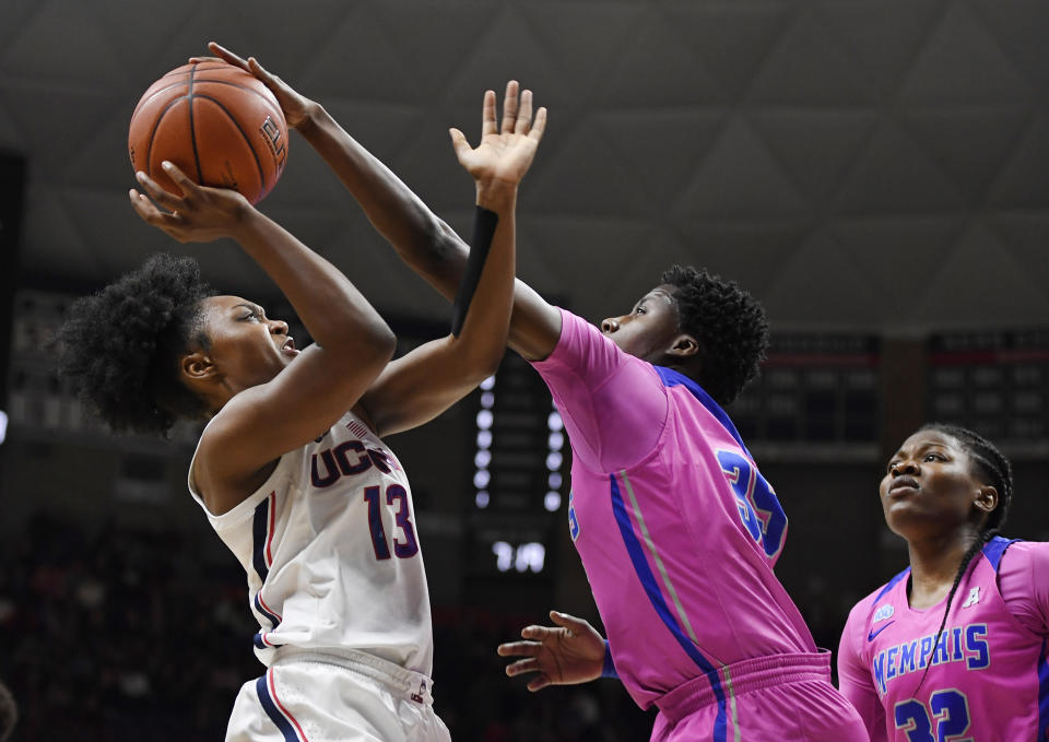 Memphis' Julan McDonald, center, blocks a shot by Connecticut's Christyn Williams, left, as Memphis' Dulcy Fankam Mendjiadeu, right, looks on in the first half of an NCAA college basketball game, Friday, Feb. 7, 2020, in Storrs, Conn. (AP Photo/Jessica Hill)