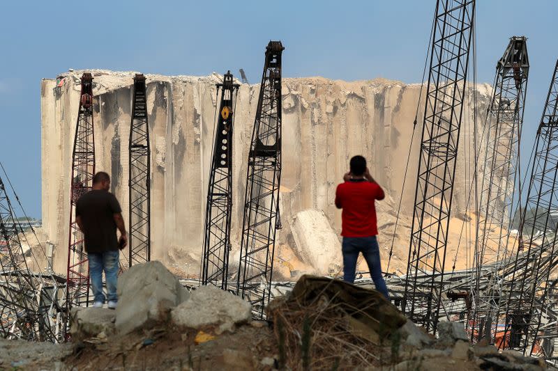 FILE PHOTO: People look at the damaged port area, following a massive explosion, in Beirut