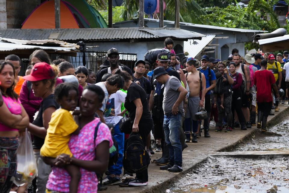 Migrants line up to show their IDs to Panamanian immigration officials as they arrive to Bajo Chiquito, Darien province, Panama, Thursday, Oct. 5, 2023, after walking across the Darien Gap from Colombia. (AP Photo/Arnulfo Franco)