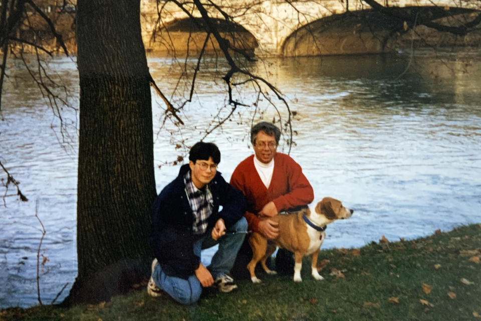 In this image provided by the Pete Buttigieg presidential campaign, Pete Buttigieg and his father Joseph pose for a photo with his first dog, Olivia, in Leeper Park next to the St. Joseph River around 1995 in South Bend, Ind. This location is across the street from his current home. (Pete Buttigieg Presidential Campaign via AP)