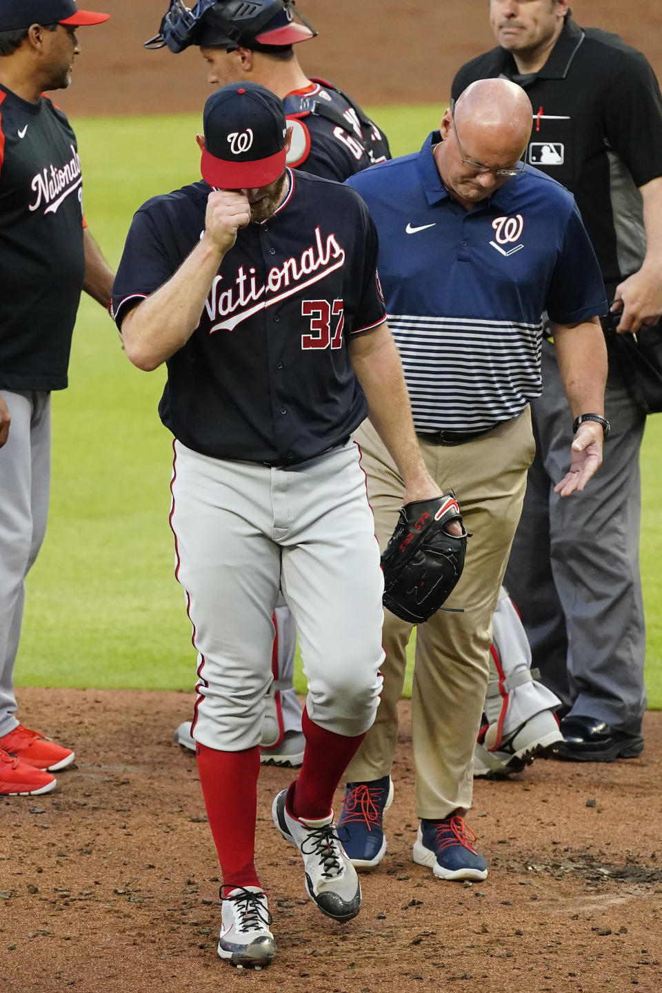 FILE - In this June 1, 2021, file photo, Washington Nationals starting pitcher Stephen Strasburg (37) leaves the field with a member of the team's medical staff in the second inning of a baseball game against the Atlanta Braves in Atlanta. Strasburg will have season-ending neck surgery, Nationals manager Dave Martinez said Tuesday, July 27, 2021, ending another frustrating year for Washington's 2019 World Series hero. (AP Photo/John Bazemore, File)