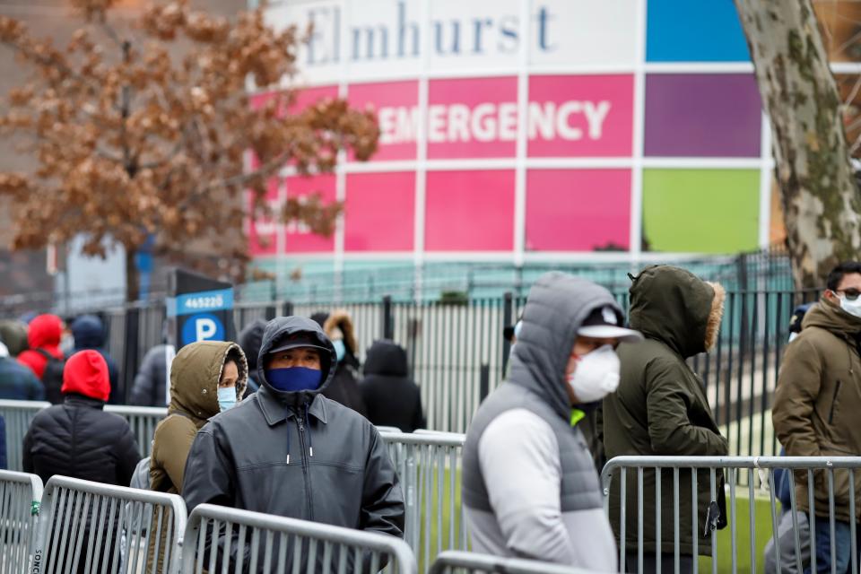 People wait in line to be tested for coronavirus disease (COVID-19) while wearing protective gear, outside Elmhurst Hospital Center in the Queens borough of New York City, U.S., March 25, 2020