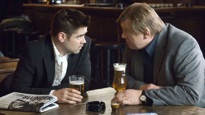 Two guys drinking beer look at each other In Bruges.