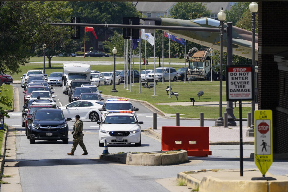 Security personnel stand at an entrance to Joint Base Anacostia-Bolling during a lockdown, Friday, Aug. 13, 2021, in Washington. The base was placed on lockdown after a report that an armed person was spotted on the base. (AP Photo/Patrick Semansky)