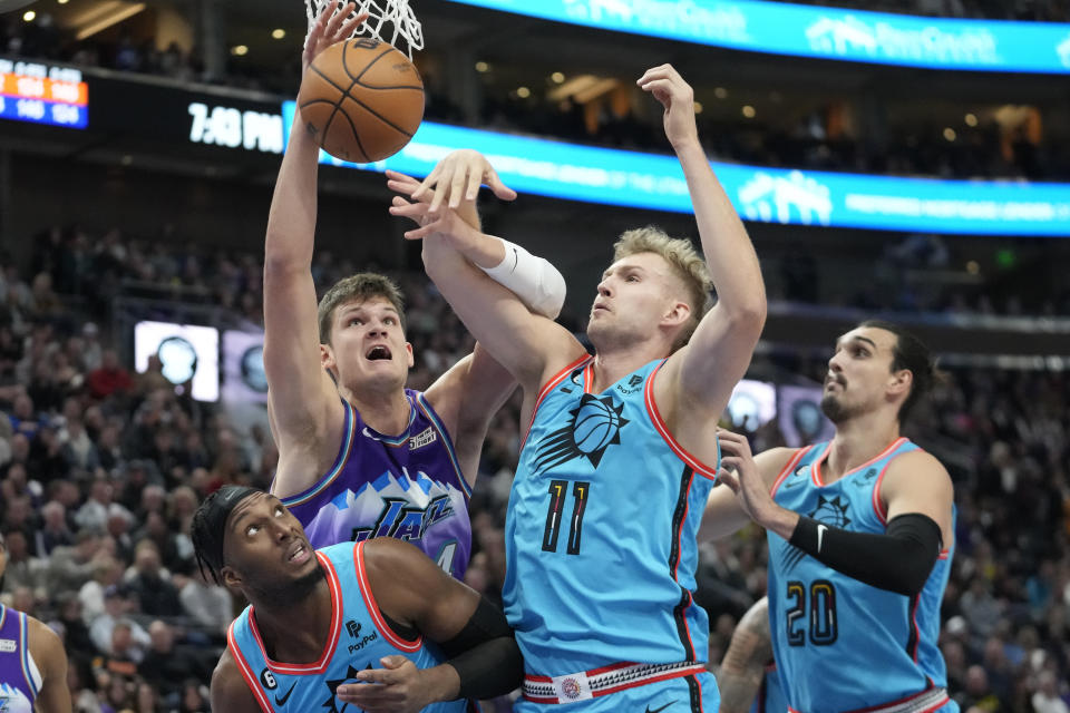 Utah Jazz center Walker Kessler, back left, and Phoenix Suns center Jock Landale (11) battle for a rebound during the first half of an NBA basketball game Friday, Nov. 18, 2022, in Salt Lake City. (AP Photo/Rick Bowmer)