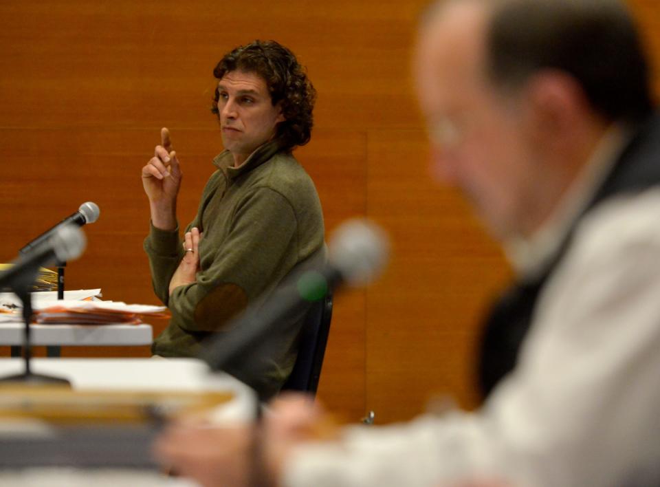 Truro voter Raphael Richter raises his hand as he waits to ask a question during the hearing of Rosemary Boyle who was not able to attend Monday's hearing and was represented by an attorney and her former husband Brian Boyle. The Truro Board of Registrars held the first night of hearings of voter registration challenges on Monday at the Truro Community Center. Richter filed 66 challenges related to voter residency in the town of Truro.