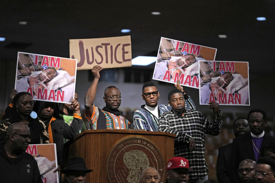 People hold signs during a news conference discussing the death of Tyre Nichols, Tuesday, Jan. 31, 2023, in Memphis, Tenn. A funeral service for Nichols, who died after being beaten by Memphis police officers, is scheduled to be held on Wednesday. (AP Photo/Jeff Roberson)